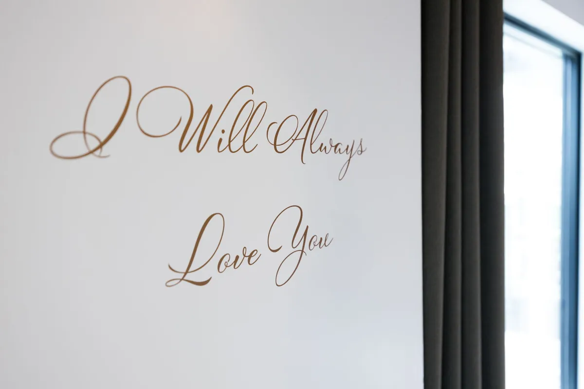 The wall features the phrase 'I Will Always Love You' in elegant script, infusing the space with sentiment and warmth. The room encourages reflection, affection, and memorable connections.